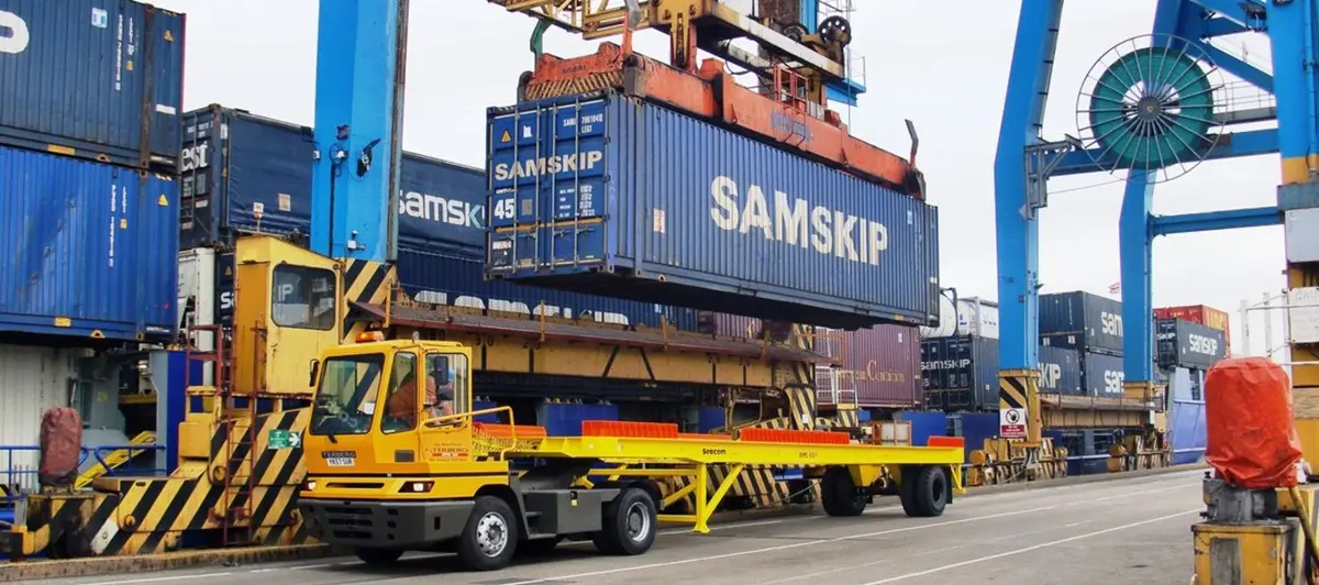 Seacom container chassis in front of a ship hull